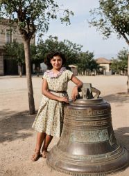 Απεικονίζεται η Ευσεβεία Μαυρίδου, μετέπειτα σύζυγος του δωρητή της φωτογραφίας, με την καμπάνα της Μεταμόρφωσης την οποία είχαν φέρει από το Κάρς οι πρόσφυγες - Καλαμαριά 1950 