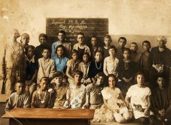 Μαθητές σχολείου με τις δασκάλες τους. Στον πίνακα η ημερομηνία Παρασκευή 29 Μαϊου το έτος άγνωστο όπως & η περιοχή λήψης της φωτογραφίας & ένας στίχος γεωργικού περιεχομένου